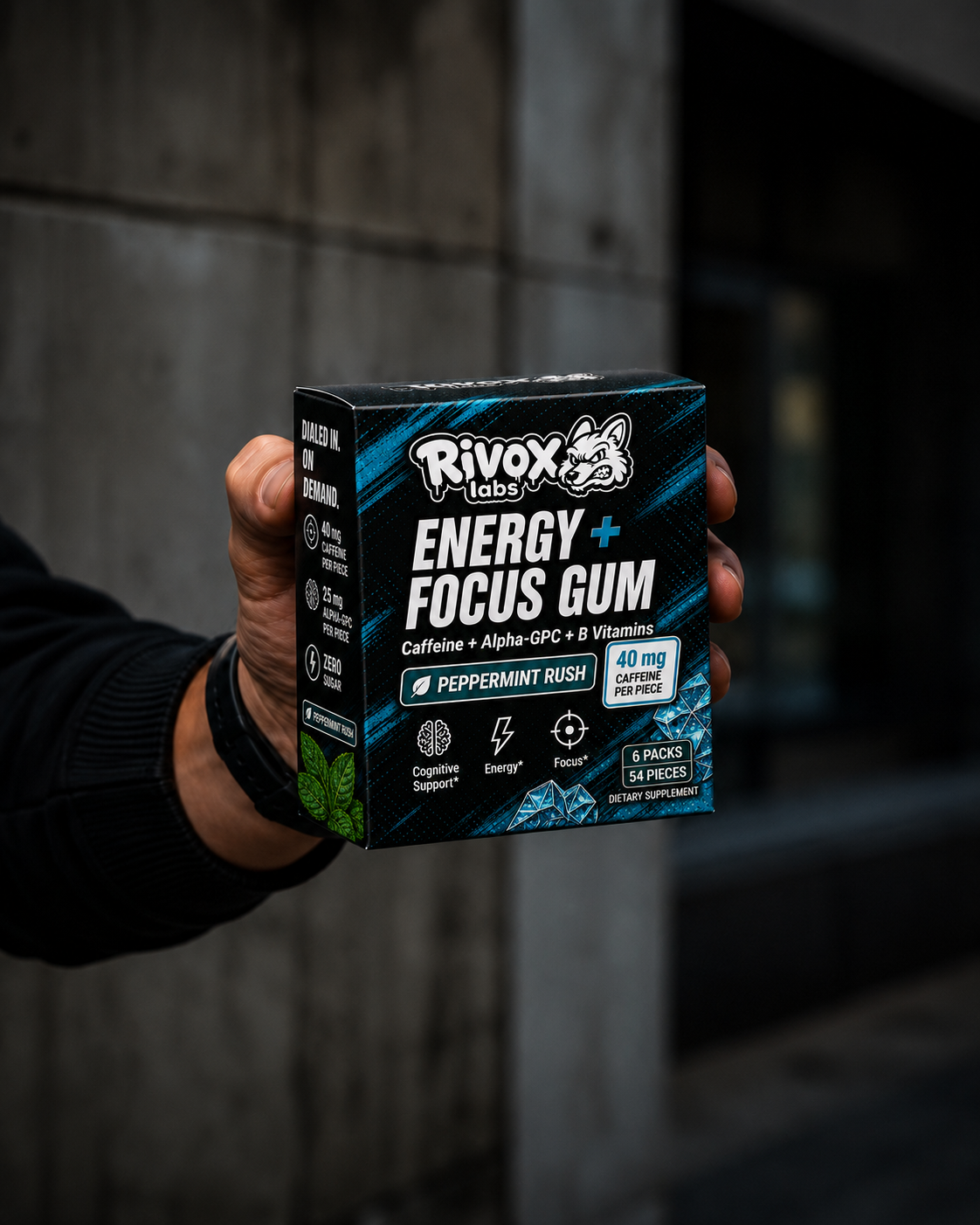 Box of Rivox Labs Energy + Focus Gum held by a person against a dark background