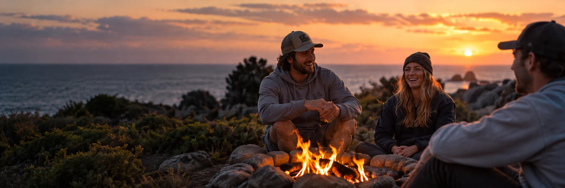 Friends sharing an evening around a coastal campfire